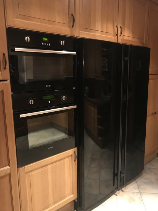 Fullstor inbyggd ugn och kylskåp i ett träkök.