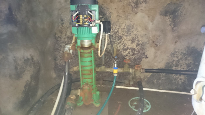 Hydrofor med vattenpump och anslutningar i en källare, frågor om funktion och luftningsprocess.