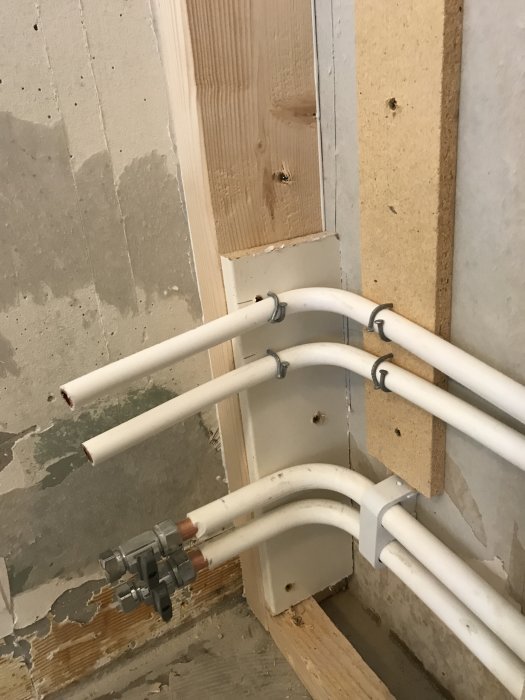 Installationsfas i badrumsrenovering med rördragning och förstärkning av väggstruktur.