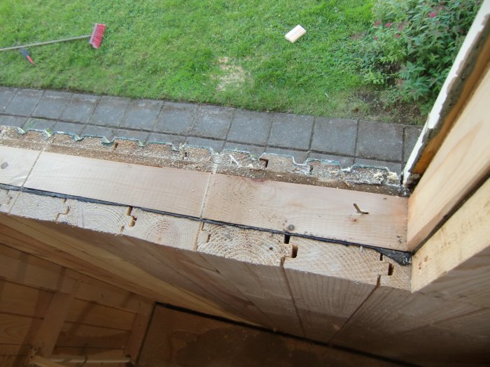 Vy av ett pågående bygge där fönsterparti har tagits bort och ersatts med nya träreglar i en vägg.