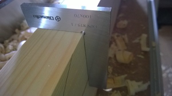 Hyvel och vägglist kontrolleras med verktyg för att säkerställa rät vinkel mot spån.