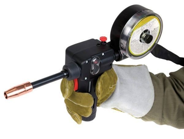Svetspistol med integrerat matarverk och trådrulle för push-pull-teknik bärs i hand med skyddshandskar.