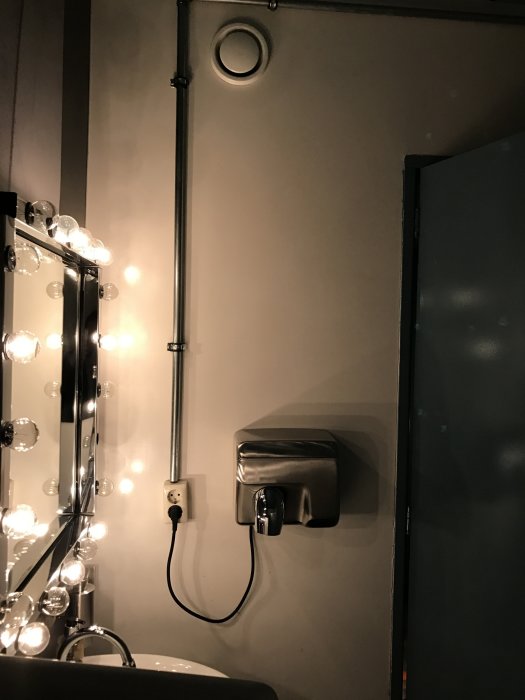 Metallrör och elektriska installationer på restaurangtoalett i Holland.