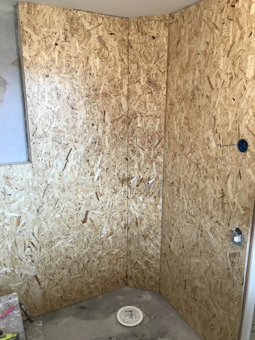 Badrumsrenovering med OSB-skivor på väggarna, eluttag och förberedelser för golvvärme.