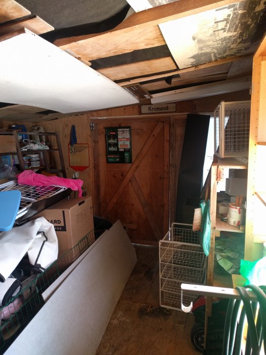 Inredning av snickarbod med verktygstavla, hyllor och olika förvaringslösningar.