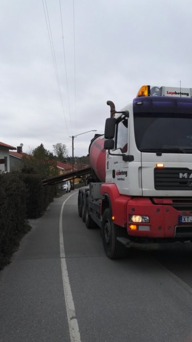 Betongbil redo för gjutning av betonggolv, parkerad längs en gata.