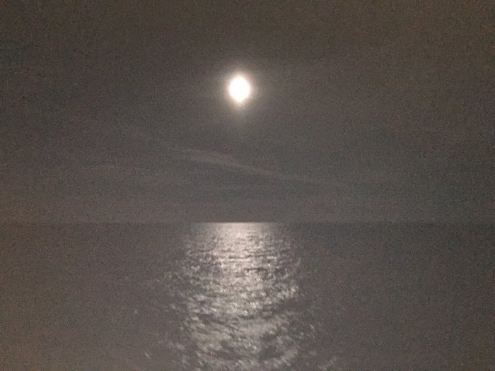 Nattbild på månen som lyser över havet från en båt nära Klaipeda, Litauen.