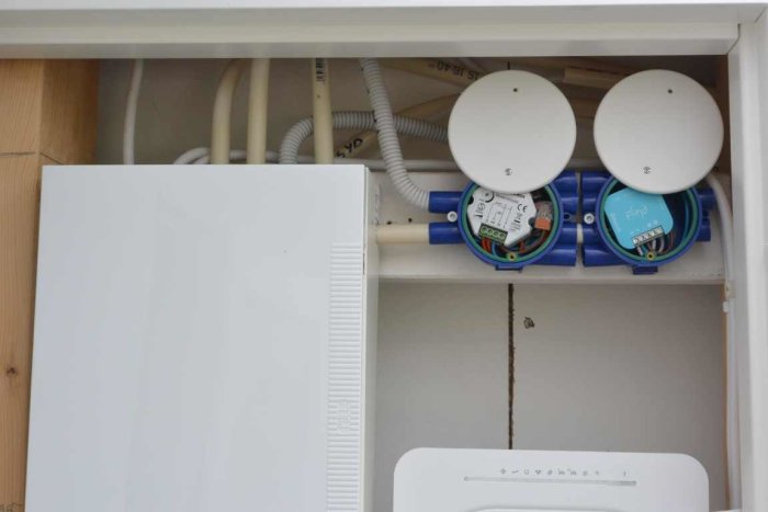 Elektriskt apparatskåp öppet, visar installation av Plejd-dimmer, kablar och dosor.