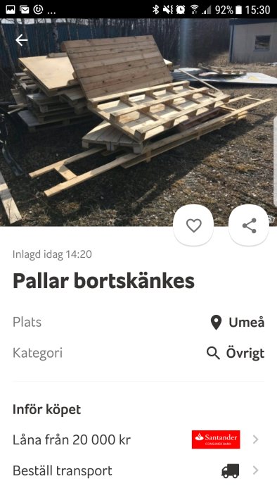 Staplade träpallar som erbjuds gratis utomhus, annonstext om bortskänkande på en köp- och säljsida.