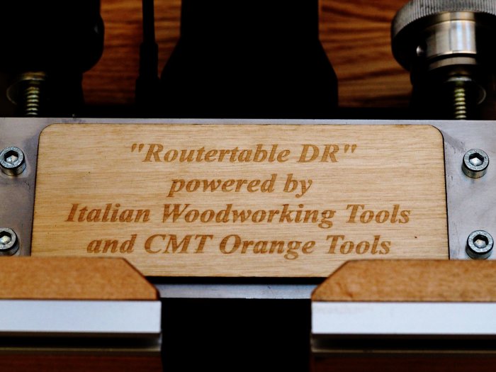 Egentillverkad träskylt på fräsbord med texten "Routertable DR powered by Italian Woodworking Tools and CMT Orange Tools".