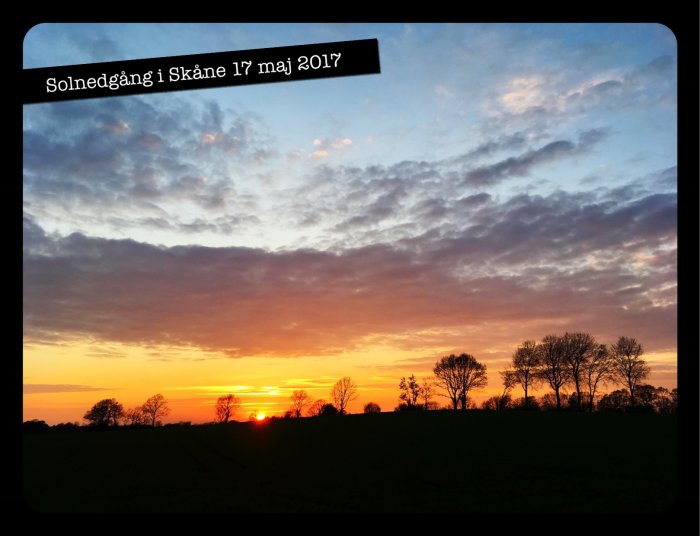 Solnedgång med dramatisk himmel över ett fält i Skåne, text överst anger datum 17 maj 2017.