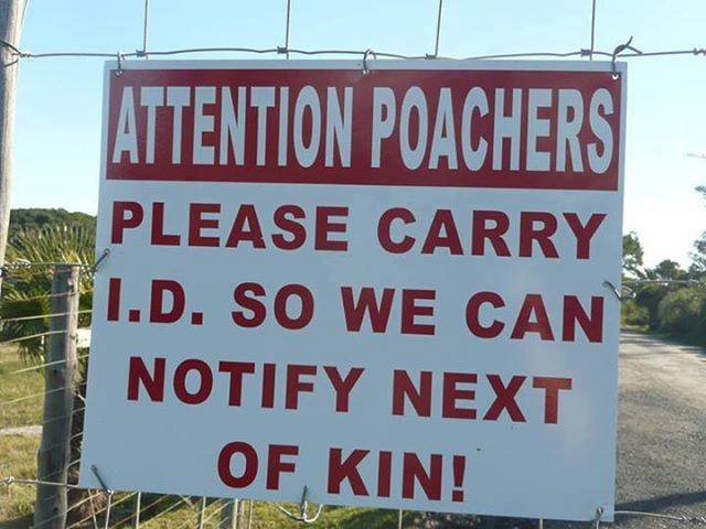 Skylt som varnar tjuvjägare med texten "Attention Poachers Please Carry I.D. So We Can Notify Next Of Kin!