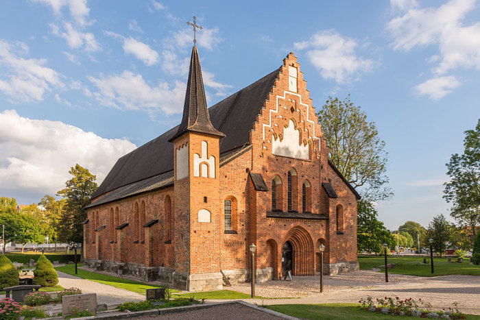 Åldrig tegelfasad på Mariakyrkan från 1250-talet i Sigtuna, välbevarad med gotiska drag och ett torn.