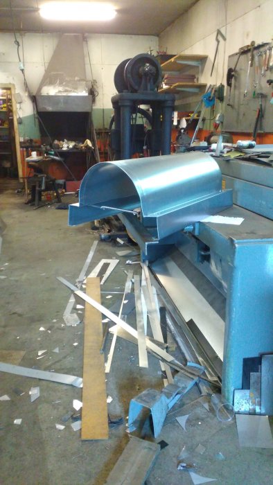Nybyggd skorstenhuv i metallverkstad med verktyg och materialrester på golvet.