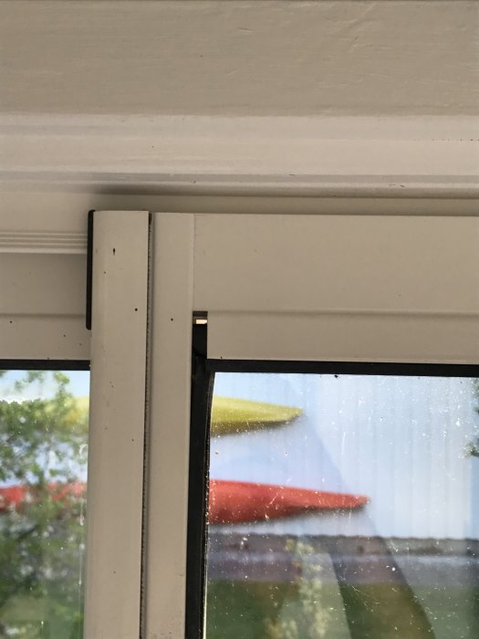Glipa mellan dörrkarm och tätningslist i ett uterum som ger en otät förslutning, med utsikt till utomhusmiljö i bakgrunden.