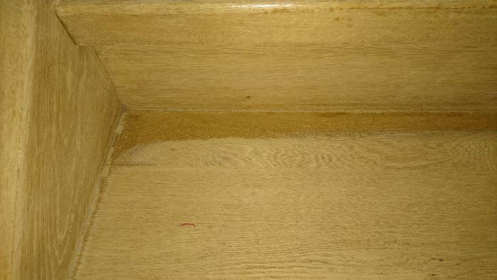 Renoverad trätrappa med slipad yta och nymålad med hårdvaxolja, färdigställande steg.