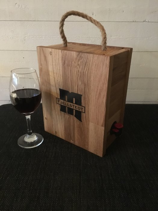 Eklimfogskiva omvandlad till hållare för öl/bag in box bredvid ett glas vin.