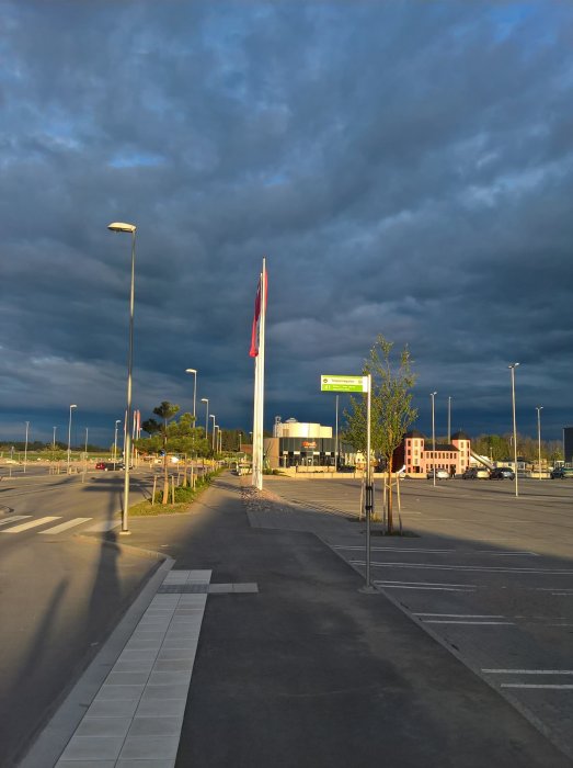 Kvällsbild av parkeringsplats i Uppsala med dramatisk himmel och flaggstång.