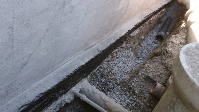 Grund konstruktion med mått 47 cm från sula till rör, dräneringsgrus och isolering synlig.