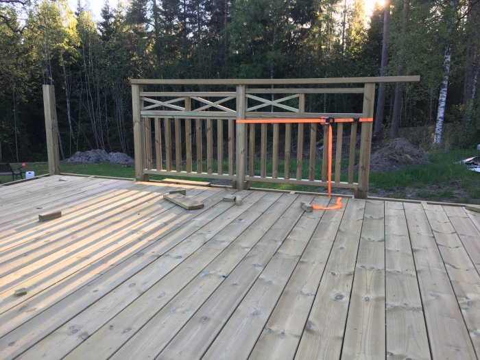Trädäck med två olika träkryssmönster för räcken testas i en skogsmiljö.