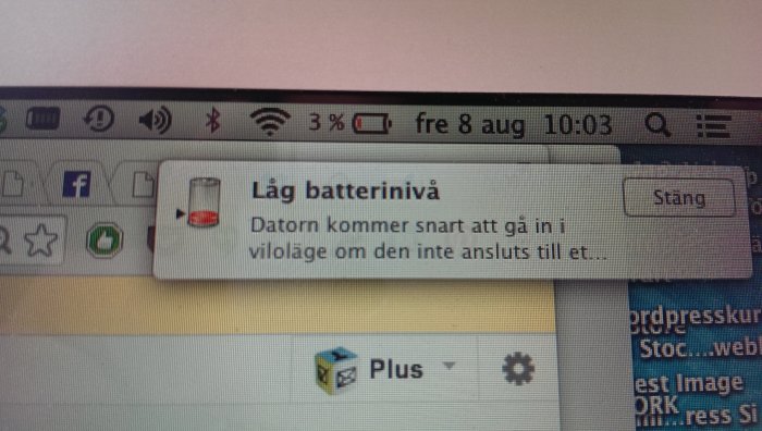 En datorskärms övre högra hörn som visar låg batterinivåvarning med klockan ställd på 10:03.