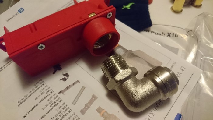 Röd LK kopplingsbox och en metallkoppling på ett dokument.