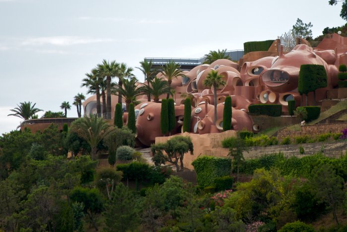 Palais Bulles, ovanligt bubbelhus med rosa kupoler och runda fönster omgivet av palmer i Frankrike.