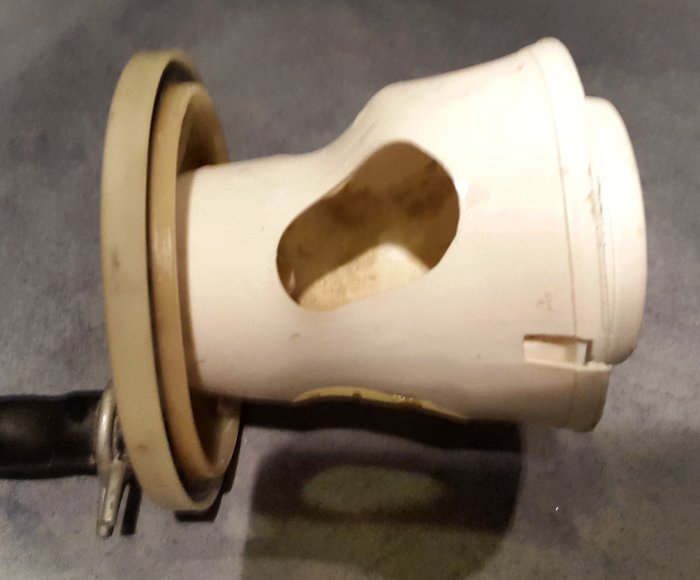 Close-up av vit avloppspumplock på en Cylinda tvättmaskin, med en synbar vattendroppe och utan filter.