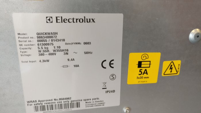 Typskylt på en Electrolux Quickwash tvättmaskin som visar modell, strömförbrukning och säkerhetsinformation.