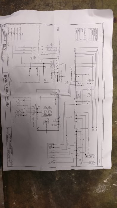 Elritning placerad på ett arbetsbord som visar ett detaljerat elektriskt schema för byggprojekt.