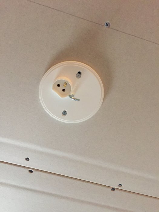 Takuttag för lampa på gipsvägg, omonterad utan belysningsarmatur.