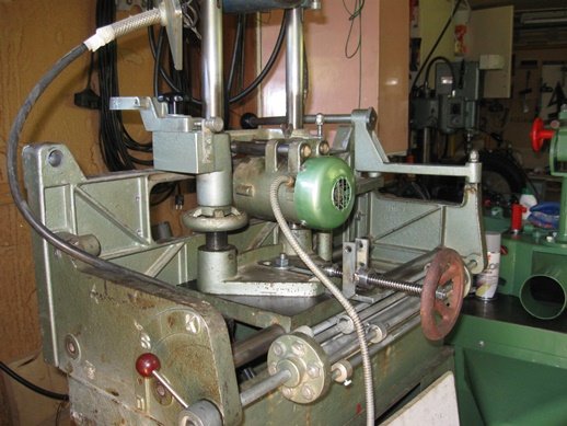 Renoverad borrmotor med nya lager och fläktkåpa på en verkstadsmaskin, synlig ställskruv och spak.