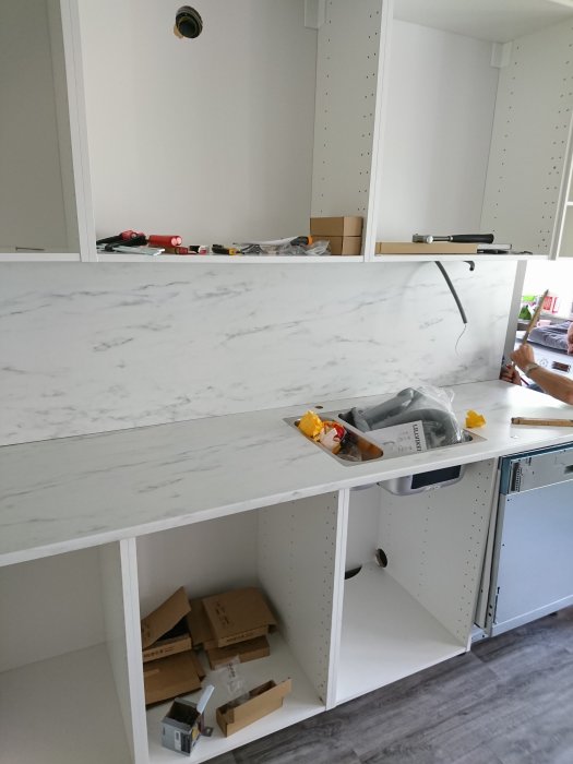 Marble-patterned countertop adjusted with a slight gap at the ends and a white wall side panel partially installed above kitchen cabinets.