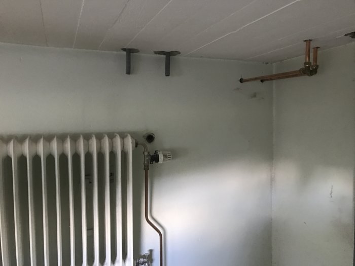 Radiator med nya kopparrör installerade i taket för värmefördelning, redo för dammsugning.