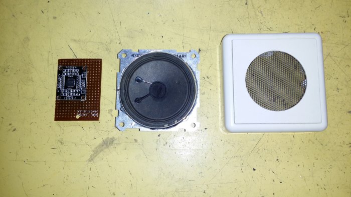 Klass D förstärkarkrets PAM8610, en liten högtalare och en apparatdosa på gul bakgrund.