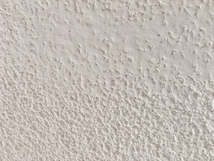 Strukturskadad yta på ett tak där textur saknas efter fläckborttagning.