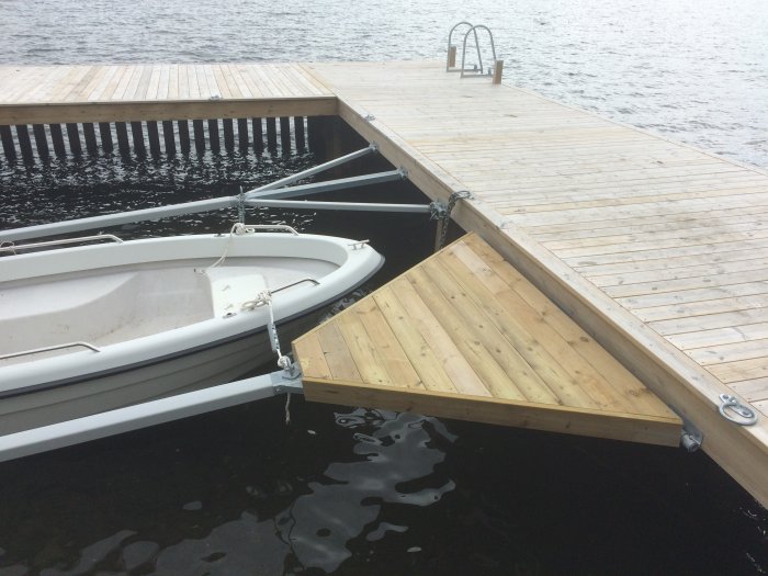 Träplattformar installerade på y-bommar vid brygga för enklare tillgång till förtöjd båt.