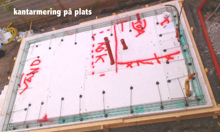 Grundplatta för attefallshus under konstruktion med rörinstallationer och markerade mått.