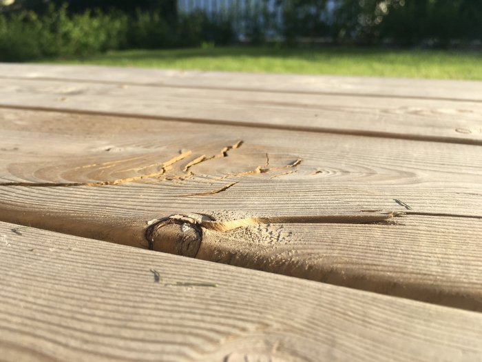 Skadad trätrall med uppsprickningar och spån, risk för skador på barfota.