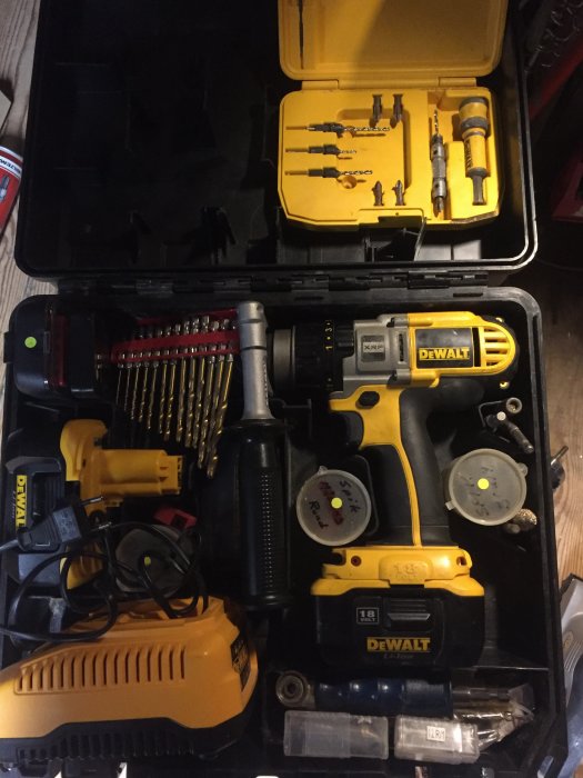 Öppen svart väska med DeWalt skruvdragare, borrsatser, hålsågar och batteri, organiserat för byggprojekt.