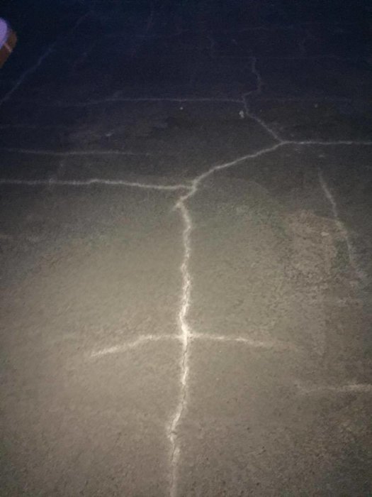 Nybetongplatta med synliga sprickor som bildats efter för lite bevattning på en varm dag.