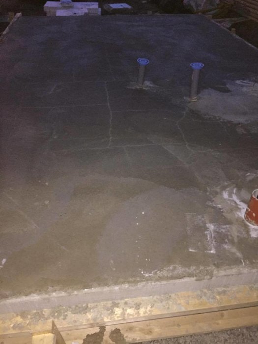 Nyinstallerad betongplatta med synliga sprickor och rörstumpar som sticker upp.