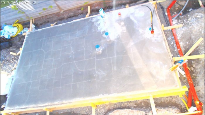 Nyutgjuten betongplatta med sprickor och byggmaterial runtomkring.