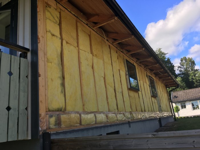 Husvägg efter rivning med synlig isolering och förberedelse för nytt fönster.