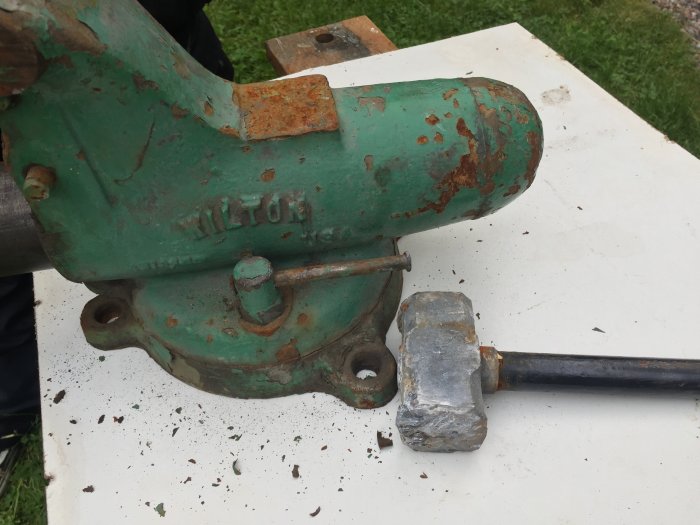 Gammalt grönfärgat skruvstäd märkt "WILTON" med rost och avflagningar, vid renovering.