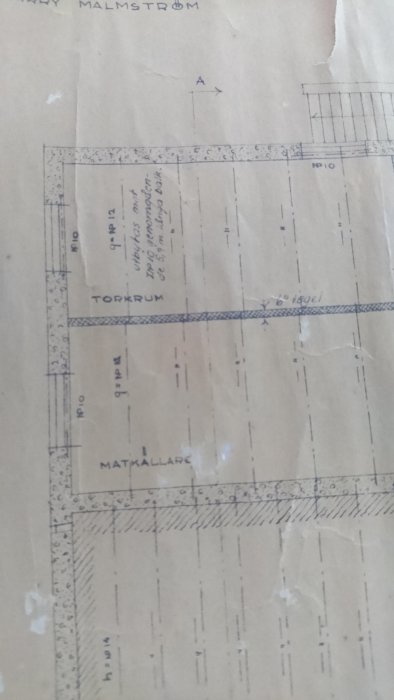 Del av en sliten byggnadsritning som visar en markerad 6-tums tegelvägg och noteringar om balkar.