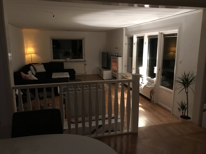 En nyligen renoverad vardagsrumsinteriör med soffa, öppen planlösning och mjukt belysning på kvällen.