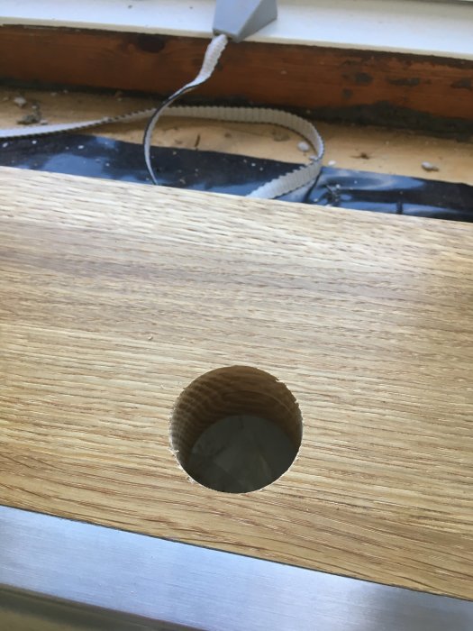 Ett 40mm hål i en ekträbänkskiva, borrat för installation av en blandare.