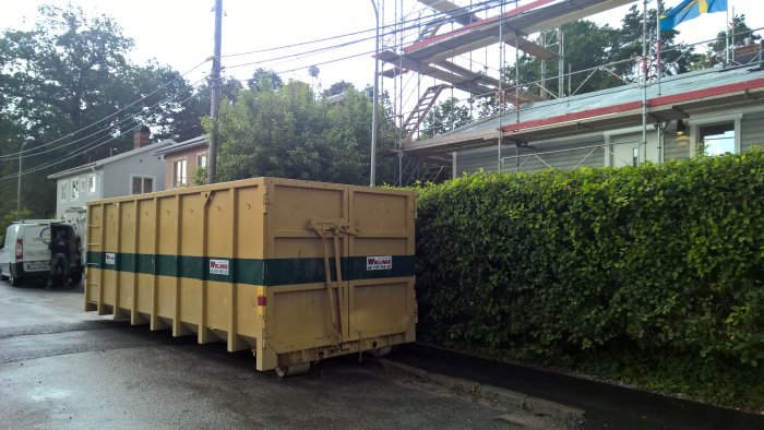 Gul 30-kubiksmeter container från Wiklunds Åkeri placerad på en byggarbetsplats.