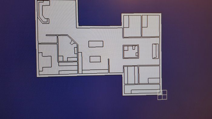 Ritad planlösning av en våning med utmärkta rum som allrum, kök, och korridorer samt inredningsdetaljer som soffa och garderob.